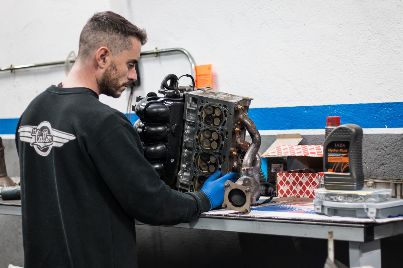 Mecánico revisando la culata de un motor desmontado sobre el banco de trabajo